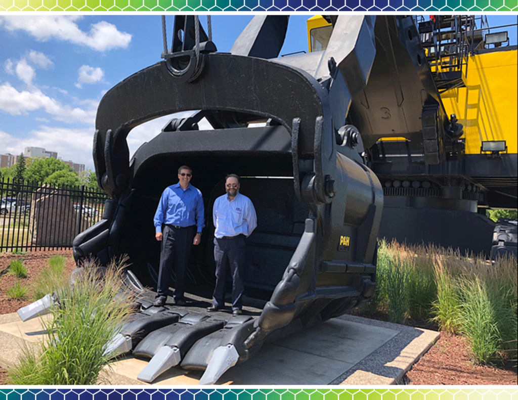 Andy Hill and Bill from HVR standing on a gigantic crane scoop.